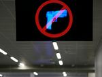 A television displays a "no guns" sign at the Transportation Security Administration security area at the Hartsfield-Jackson Atlanta International Airport on Wednesday, Jan. 25, 2023, in Atlanta. Last year saw a record number of guns intercepted at airport checkpoints across the country.