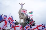 A demonstrator stands on the head of the South Bank lion that sits on the side of the Westminster Bridge, during a Tommy Robinson-led Unite the Kingdom march and rally in London, on Saturday.