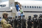 Venezuelan migrants accused by the U.S. of belonging to the Tren de Aragua criminal gang are seen being transferred from the Terrorism Confinement Center (Cecot) in El Salvador before being repatriated to Caracas on July 18, 2025 in La Paz, El Salvador.