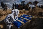 Palestinians bury the bodies of people who were killed in fighting with Israel and returned to Gaza by the Israeli military, during a mass funeral in Rafah, in southern Gaza, on Tuesday, Jan. 30.