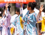 Dancers perform traditional fan dancing while on stage.