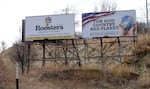 A billboard on a hill depicts a globe in a pair of hands. The words next the picture say, "For God, Country and Planet. Have your say: patriotplanet.us."