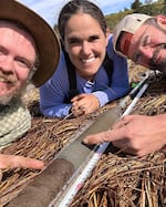 Virginia Tech researchers David Bruce, Tina Dura and Mike Priddy (left to right) snapped this selfie with a core sample on the Oregon Coast.  The gray sand stripe in the middle is evidence of the 1700 Cascadia earthquake.