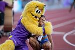 McLaughlin, of the United States, and Legend the Bigfoot mascot embrace after her race.