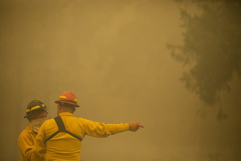 Firefighters give directions during the Santiam Fire near Gates, Ore., Sept. 9, 2020.