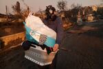 Thurs., jan. 9: Josh Lederer wears a mask to protect him from fumes as he retrieves his children's clothes from his fire-raved property in the Pacific Palisades neighborhood