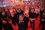 A pilgrim raises his hands and chants amid the crowds