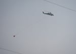 A firefighting helicopter flies in the smokey skies near the Bench Fire in Madras, Ore., on July 28, 2026.