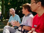 Activist Wan Yanhai (middle) talks with newly arrived Chinese migrants whom he has been helping navigate settling in the U.S.