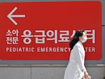 A medical worker walks past a sign for a pediatric emergency centre outside a hospital in Seoul on April 1, 2024.