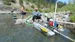 A couple uses a dredge mine to search for gold on the Illinois River in Southern Oregon. Miners argue there is little scientific evidence their dredges harm fish.
