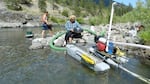 A couple uses a dredge mine to search for gold on the Illinois River in Southern Oregon.  Miners argue there is little scientific evidence their dredges harm fish. 