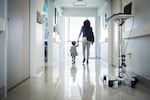 A woman and toddler are shown in a hospital corridor.