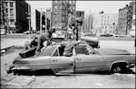 USA. New York City. 1987. Harlem street scene. Child playing in an abandoned car.