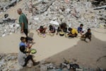 Displaced Palestinian children eat food after receiving aid distributed by a charity at Jabalia refugee camp in Gaza City, Gaza, on Sept. 23.