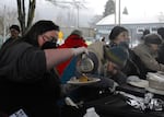 Volunteers serve breakfast at Washington Jefferson Park in Eugene, Ore., on Dec. 6, 2024.