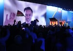 Elon Musk appears onscreen at a campaign rally in Germany.