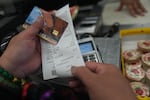 A SNAP recipient checks her balance left after purchasing food supplies with a California EBT card in Los Angeles on Oct. 31, 2025.
