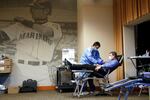 Former Seattle Mariners baseball player Dan Wilson leans back as blood collection specialist Niilo Juntunen works on Wilson's blood donation at a pop-up blood donor event at the Mariners' ballpark Monday, April 13, 2020, in Seattle.