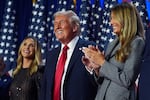 Republican President-elect Donald Trump stands on stage with former first lady Melania Trump, as Lara Trump watches, at an election night watch party at the Palm Beach Convention Center, Wednesday, Nov. 6, 2024, in West Palm Beach, Fla.