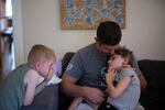 Tyler Hoyt holds his daughter, Winnie, while his son, Emmett, looks on. Emmett also qualifies for Medicaid because of his family's income.