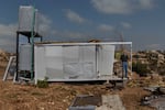 Maroun el Ras, Lebanon. September 26, 2025. Portrait of Hussein Allawiyya, a retired teacher who lost his home after the February ceasefire. Now living in Bint Jbeil, he has placed a container in front of his destroyed house. Diego Ibarra Sánchez for NPR
