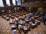 Democratic members of the Oregon Senate stand in the mostly empty Senate chambers at the Oregon Capitol in Salem, Ore., on Thursday, June 27, 2019. On the eighth day of a walkout by Republican senators, Oregon Senate President Peter Courtney adjourned the session shortly after it began due lacking the required number of senators to meet a quorum.