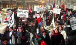 Hundreds of demonstrators wave signs and shout as they march through the streets of Washington, D.C., Jan. 20, 2001, in protest of the inauguration of U.S. President-elect George W. Bush.