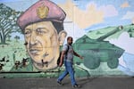 A man walks next to a graffiti with the image of the late Venezuelan President Hugo Chávez in Caracas. Political scientists say that President Trump does not enjoy the huge popular support that leaders like Chavez harnessed to dominate their nation's political systems.