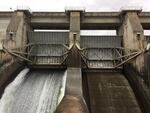 Water flows through an open spill bay at The Dalles Dam.