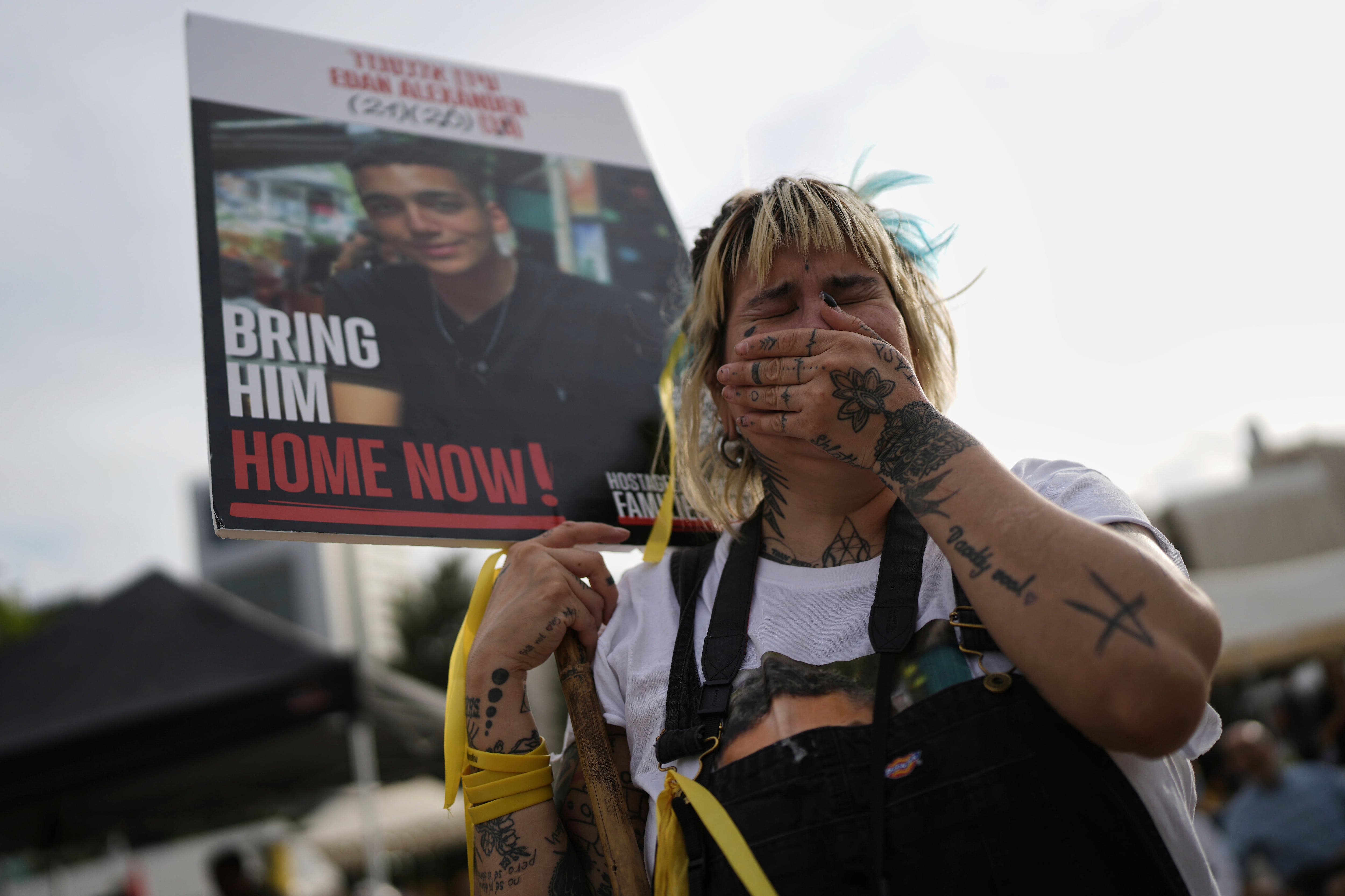 A woman cries as she gathers with others to watch a live broadcast of Israeli-American soldier Edan Alexander to be released from Hamas captivity in Gaza, at a plaza known as the hostages square in Tel Aviv, Monday, May 12, 2025. Alexander was abducted during the Hamas-led attack on his base on October 7, 2023.