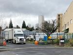 Trucks leave the Mondelez International bakery facility in Portland, Feb. 3, 2022. Workers say they're often forced to work overtime with inadequate notice.