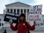 Grace Bisch holds a picture of her stepson Eddie Bisch, who died from an overdose, while protesting during oral arguments Dec. 4 at the Supreme Court in Washington, DC. The Supreme Court's ruling on June 26 upended a proposed nationwide settlement with Purdue Pharma, the manufacturer of OxyContin. Members of the Sackler family, who owned the company, will have to negotiate a new settlement for lawsuits over the impact of opioids. 