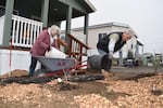 Volunteers Louise Parker and Mike Skinner spread mulch on the new pollinator garden in front of Christy Sloan's home.