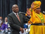 South African President Cyril Ramaphosa raises his hand as he is sworn is as a member of Parliament ahead of an expected vote by lawmakers to decide if he is reelected as leader of the country in Cape Town, South Africa, Friday. At right is Pemmy Majodina, a lawmaker with his African National Congress party.