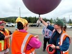 Instructor Angie Dieffenbach holds onto a large balloon and tells the girls how to safely hold it as they walk around.