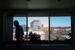 FILE - With a view of Portland, Ore., in the background, a tenant walks in the common room at The Starlight affordable housing building that is run by Central City Concern, March 15, 2024.