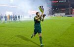 Portland Timbers midfielder Diego Valeri (8) carries the Western Conference Championship Trophy over to the Timbers Army at Toyota Stadium.