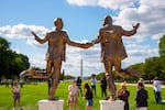 Onlookers take pictures of the statue on Thursday, with the Washington Monument visible behind them.