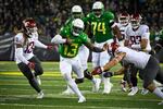 Oregon quarterback Anthony Brown (13) tries to avoid the tackle of Washington State defensive end Ron Stone Jr. (10) and linebacker Jahad Woods (13) during the third quarter of an NCAA college football game Saturday, Nov. 13, 2021, in Eugene, Ore.