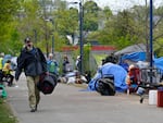 A man carries a sleeping bag at a homeless encampment in Portland, Maine, in May, before city workers arrived to clean the area. State officials say a lack of affordable housing is behind a sharp rise in chronic homelessness.