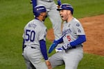 Los Angeles Dodgers' Mookie Betts (50) and Freddie Freeman (5) celebrate after scoring against the New York Yankees during the fifth inning in Game 5 of the baseball World Series, Wednesday, Oct. 30, 2024, in New York. (AP Photo/Seth Wenig)