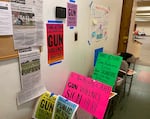 Signs on walls and taped to chairs say things like "If you really care about gun violence, sign here."