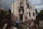 Lea Chazin stands beside the remains of a building behind her home that was destroyed by the Eaton Fire.