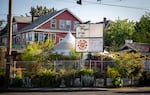 A sign advertises a Kim Jong Grillin food cart location outside the Cartopia cart pod on the corner of SE Hawthorne 12th in Portland, Ore., on Thursday, May 7, 2020. Owner Han Ly Hwang said closing seemed like the obvious choice in March when the governor's stay-home order went into effect. He's since reopened the cart for contactless orders.