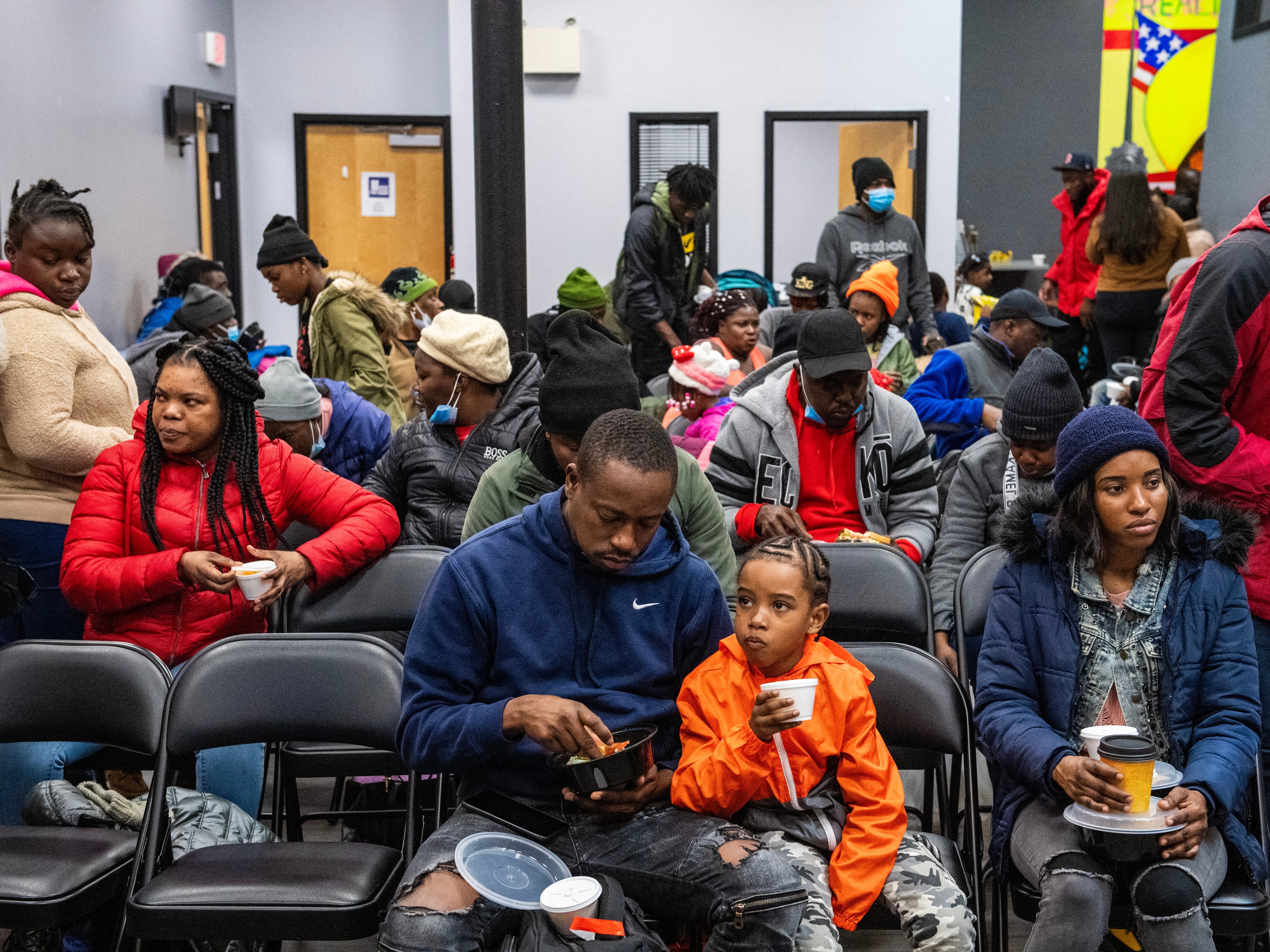 Migrants eat a meal at the La Colaborativa day shelter in Chelsea, Massachusetts, on February 22, 2024. The shelter opened on February 20, and helps migrants, mainly from Haiti, build resumes, get work, receive health care. 