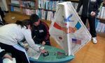 Students at Okuki Elementary in Japan finish sealing the hull on the ship American students built for them.