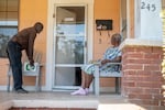 Councilman Vernon Hartley brings water to Christine Webb in Jackson, Miss., on Sept. 22, 2022.