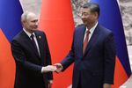 Russian President Vladimir Putin and Chinese President Xi Jinping shake hands during a bilateral meeting on Thursday in Beijing, China.