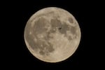 FILE - A plane passes in front of the moon, Aug. 30, 2023, in Chicago. Scientists have confirmed a cave on the moon, not far from where Neil Armstrong and Buzz Aldrin landed 55 years ago this week, and suspect there are hundreds more that could house future astronauts.